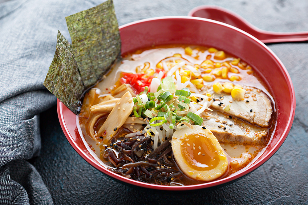 Tazón rojo de Ramen sobre fondo gris.